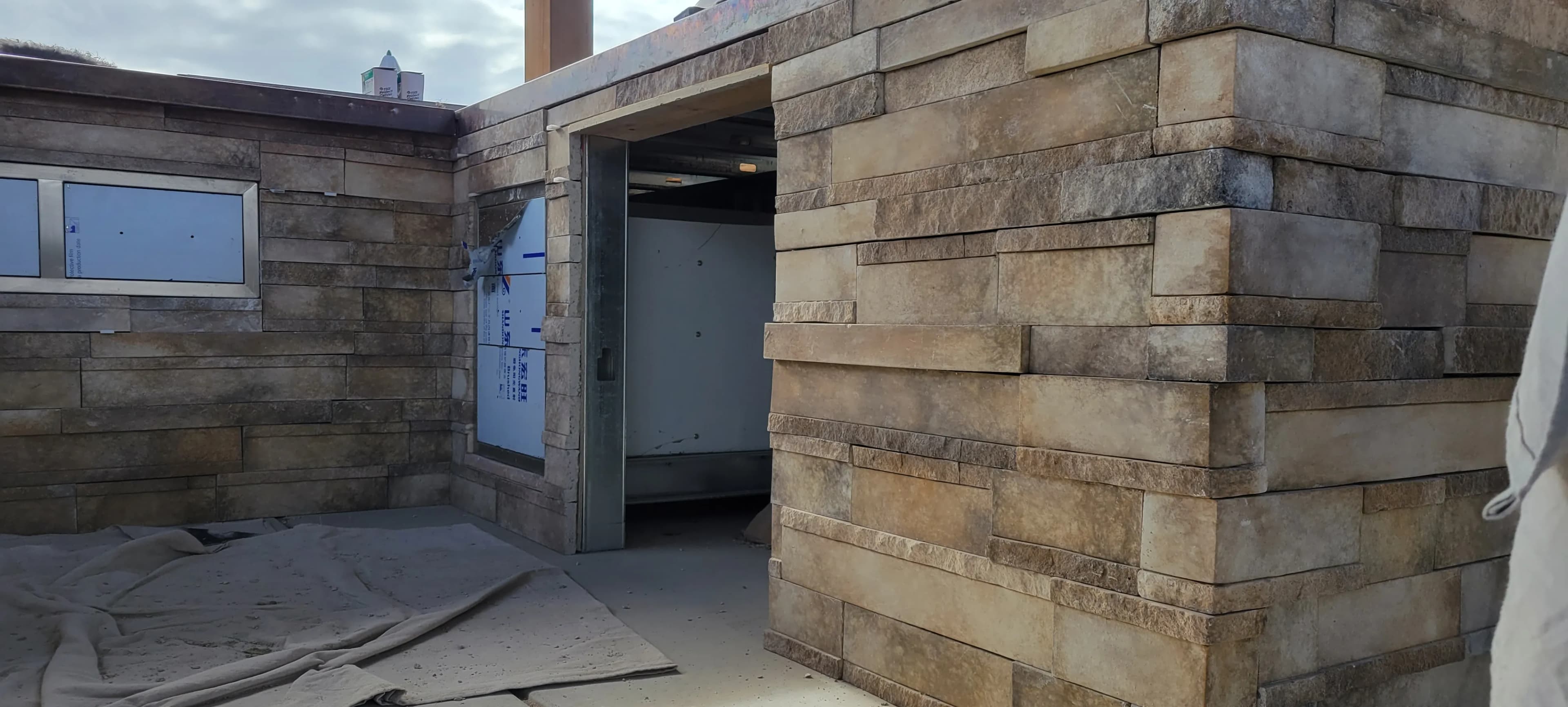 Exterior space with stacked stone walls and concrete flooring